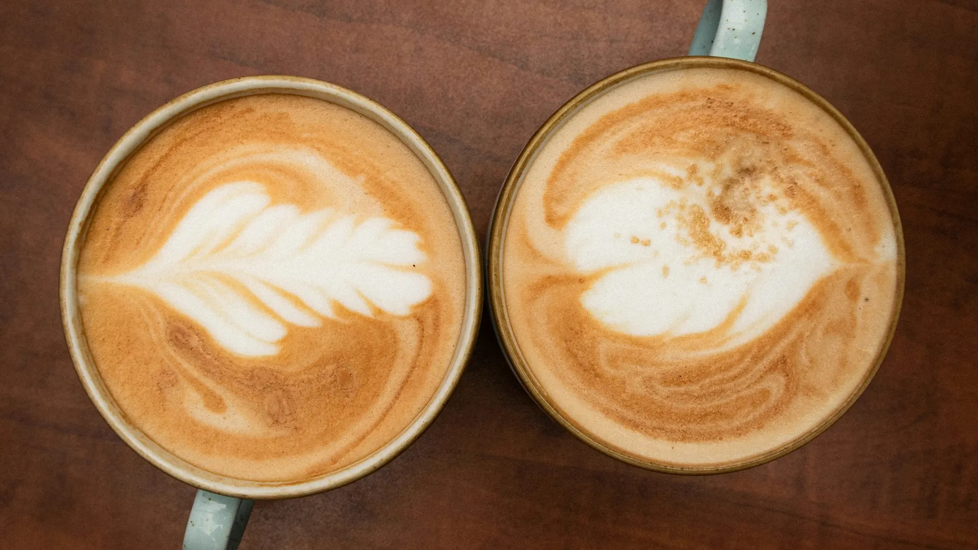 tiêu chuẩn chọn bạn đời: Hai tách cà phê latte đặt cạnh nhau trên mặt bàn gỗ ấm cúng