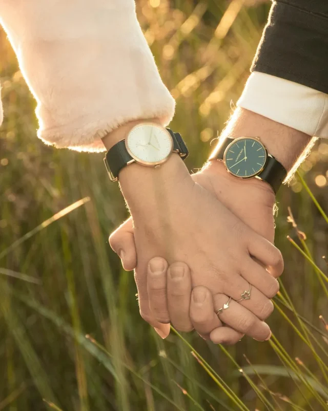 Hai bàn tay nắm chặt giữa cánh đồng cỏ